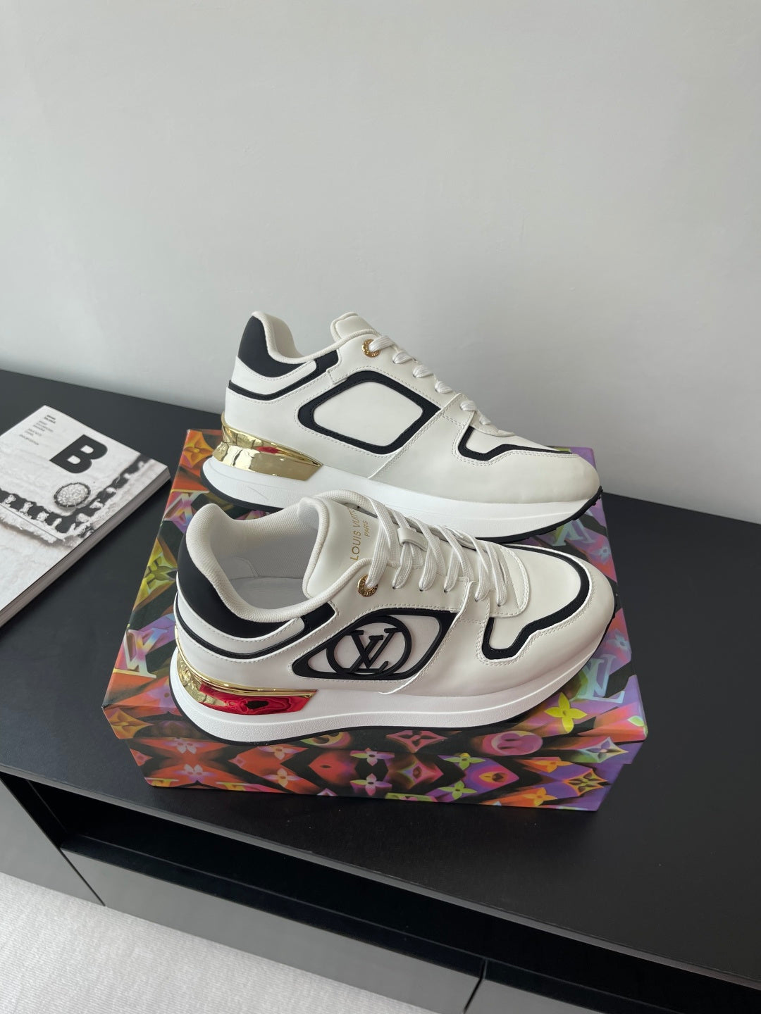 White Louis Vuitton sneakers with black trim and side logo, shown from above