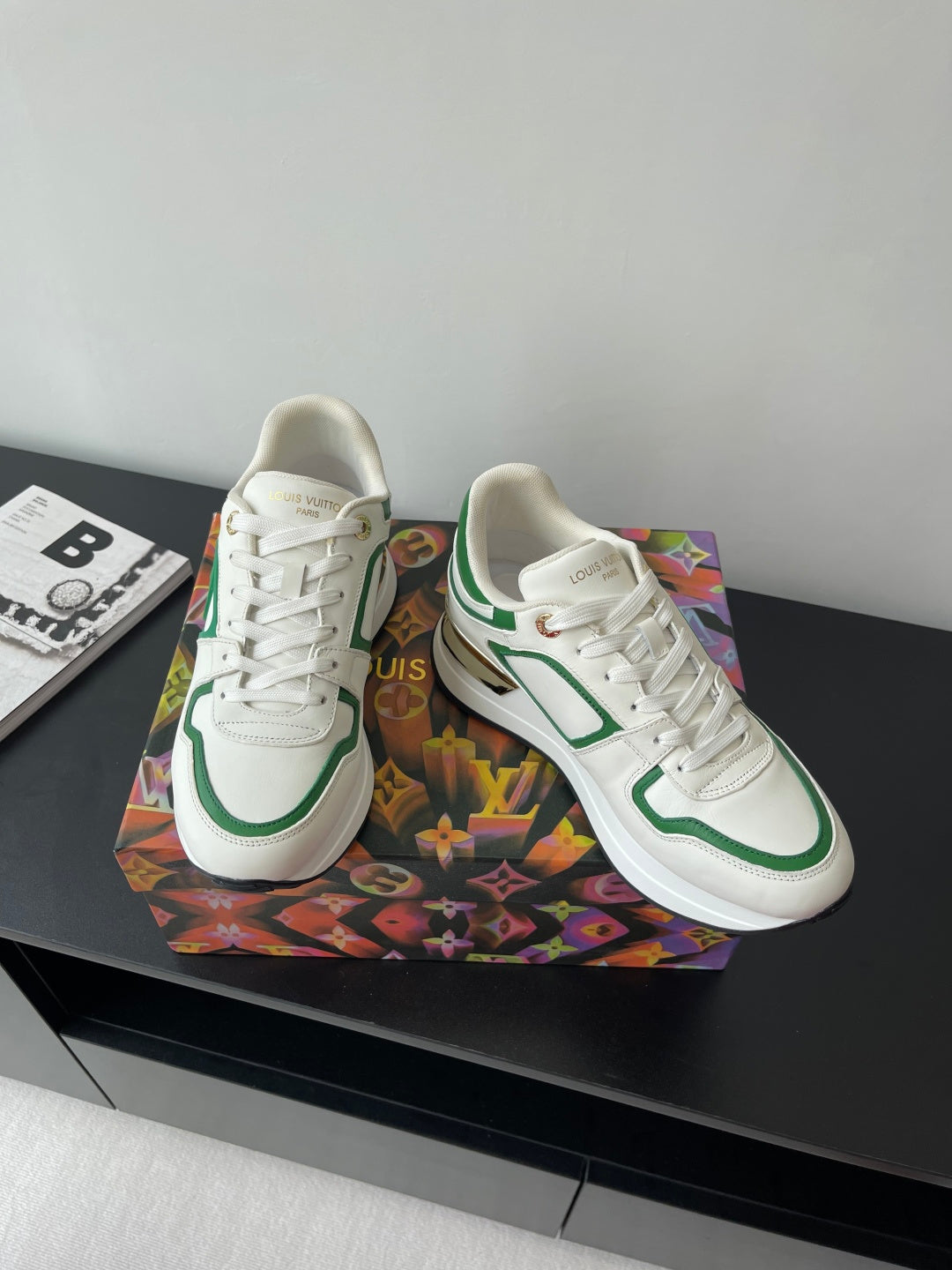 Louis Vuitton women's sneakers angled view, white with green piping and lace eyelets.