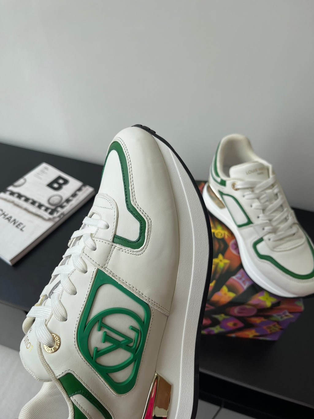 Louis Vuitton women's sneakers side profile, white with green emblem and trim.