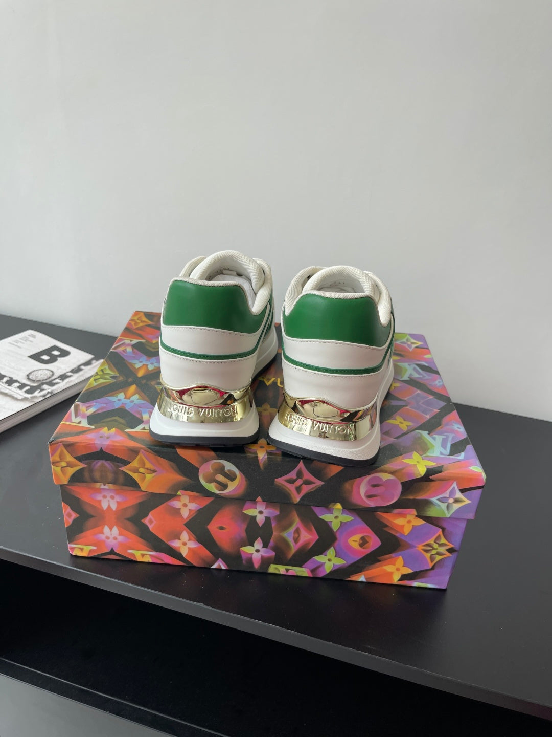Louis Vuitton women's sneakers back view, white with green heel stripe and lace tabs.