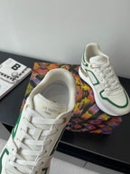 Louis Vuitton women's sneakers close-up, white leather with green collar trim.