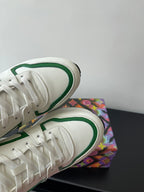 Louis Vuitton women's sneakers toe close-up, white with green edge piping.