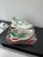 Louis Vuitton women's sneakers top view, white with green panels and low profile sole.
