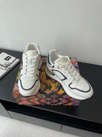 White lace-up sneakers with navy side logo on multicolor box