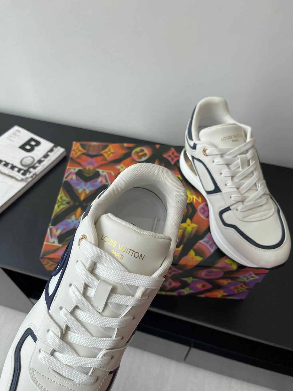 White leather sneakers with navy trim, lace-up front, cushioned collar