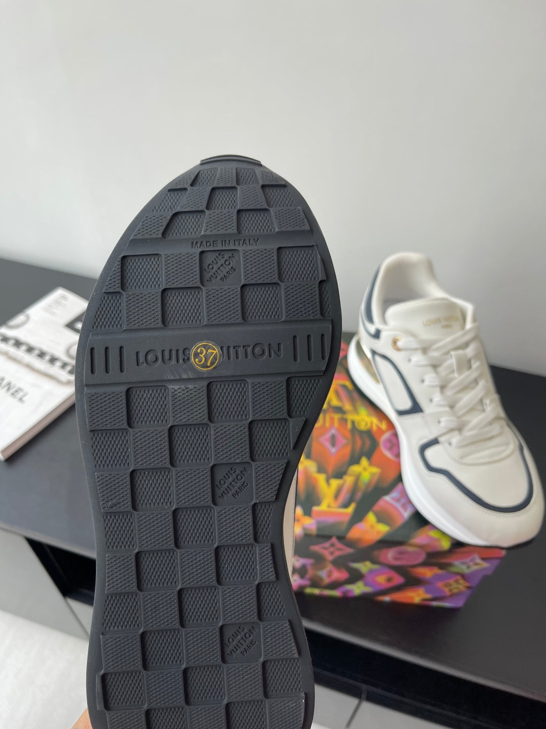 Black treaded sneaker outsole with “Louis Vuitton” logo badge