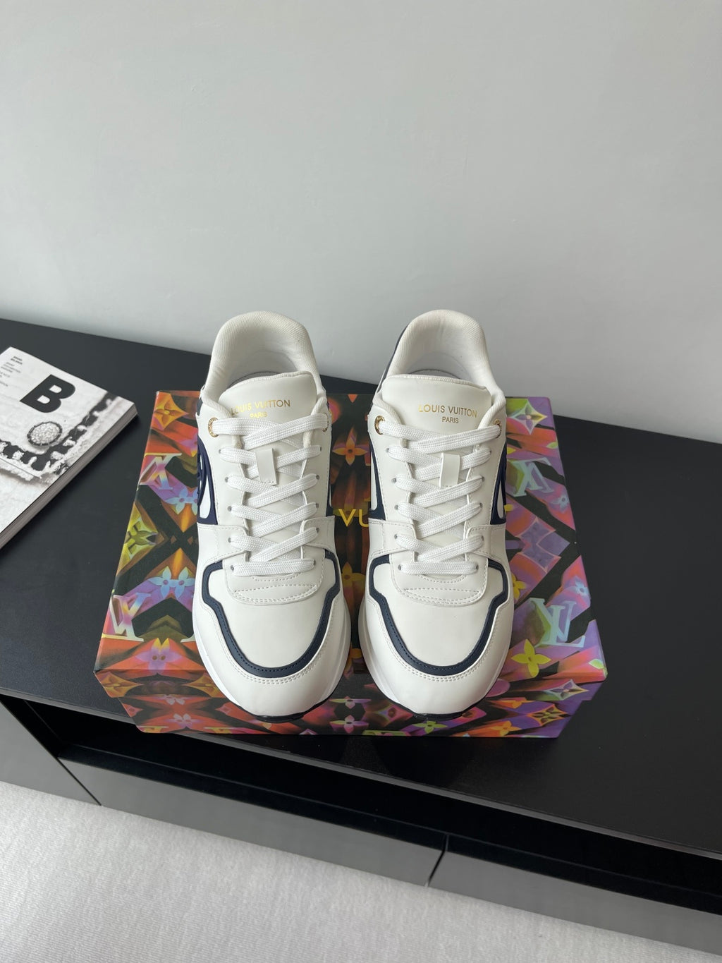 White lace-up sneakers with navy logo and cushioned sole