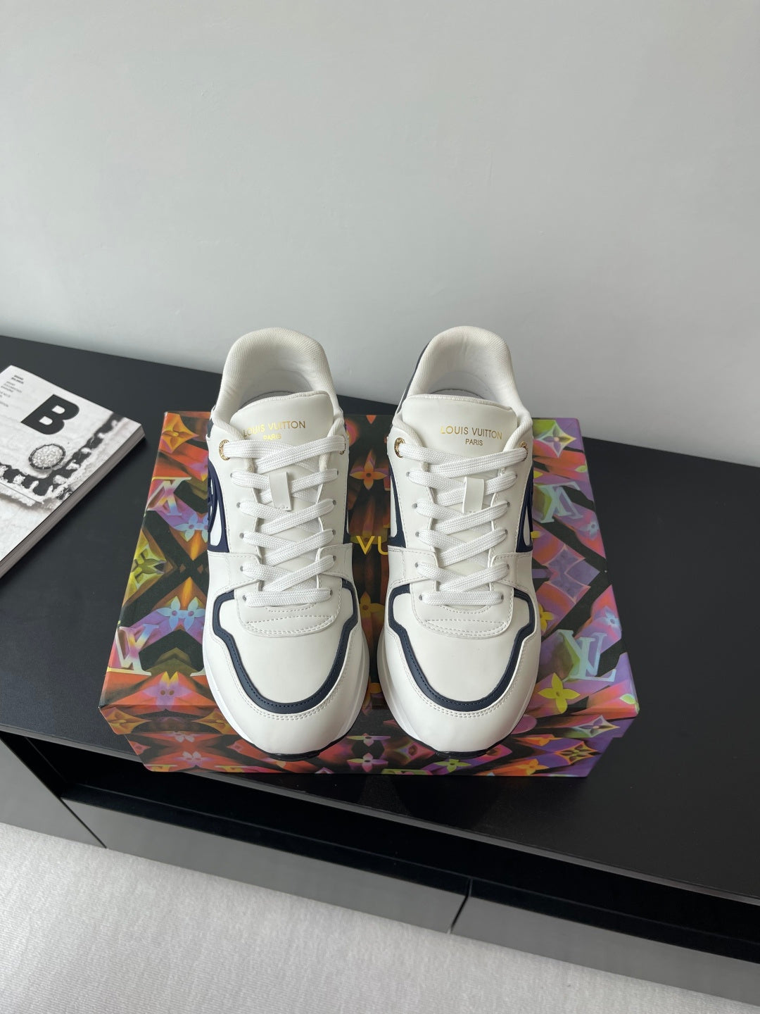 White lace-up sneakers with navy logo and cushioned sole