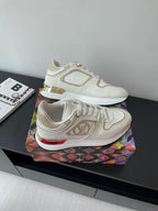 Louis Vuitton white sneakers, angled view showing gold and red trim on midsole