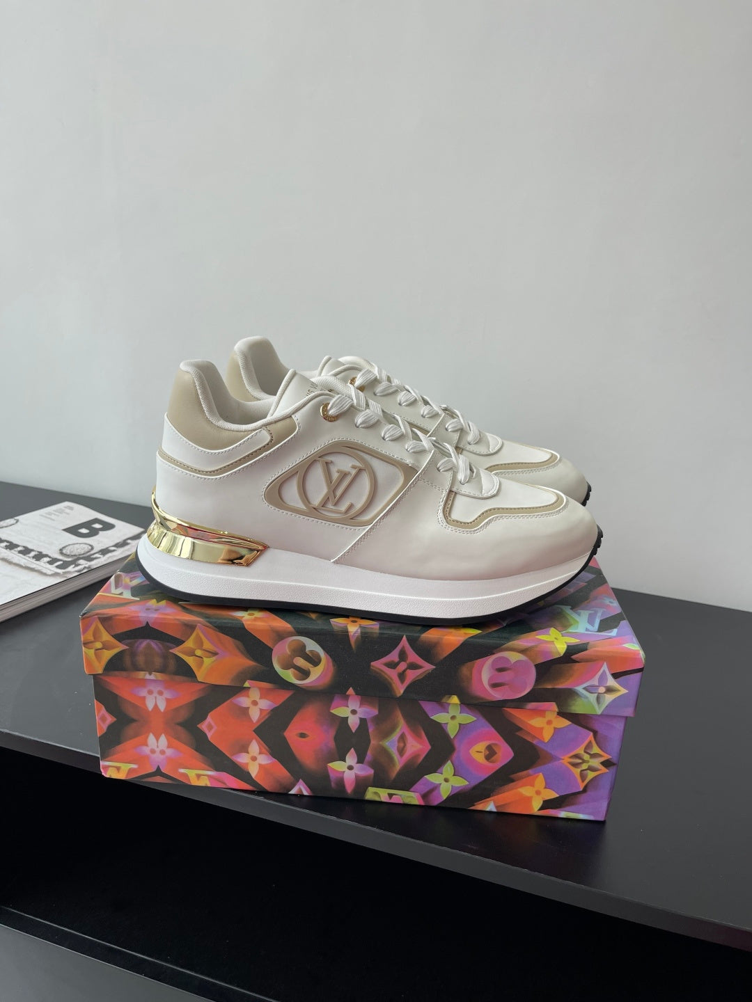 Louis Vuitton sneakers with LV emblem, white upper and gold trim on side