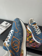 Louis Vuitton ladies sneakers side view, blue with orange trim and LV-style emblem.