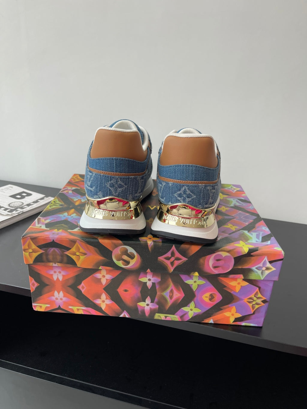 Louis Vuitton ladies sneakers back view, blue uppers with orange heel accents and laces.