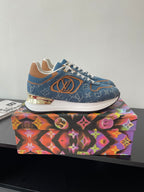 Louis Vuitton ladies sneakers in blue with orange LV-style logo and white midsole.