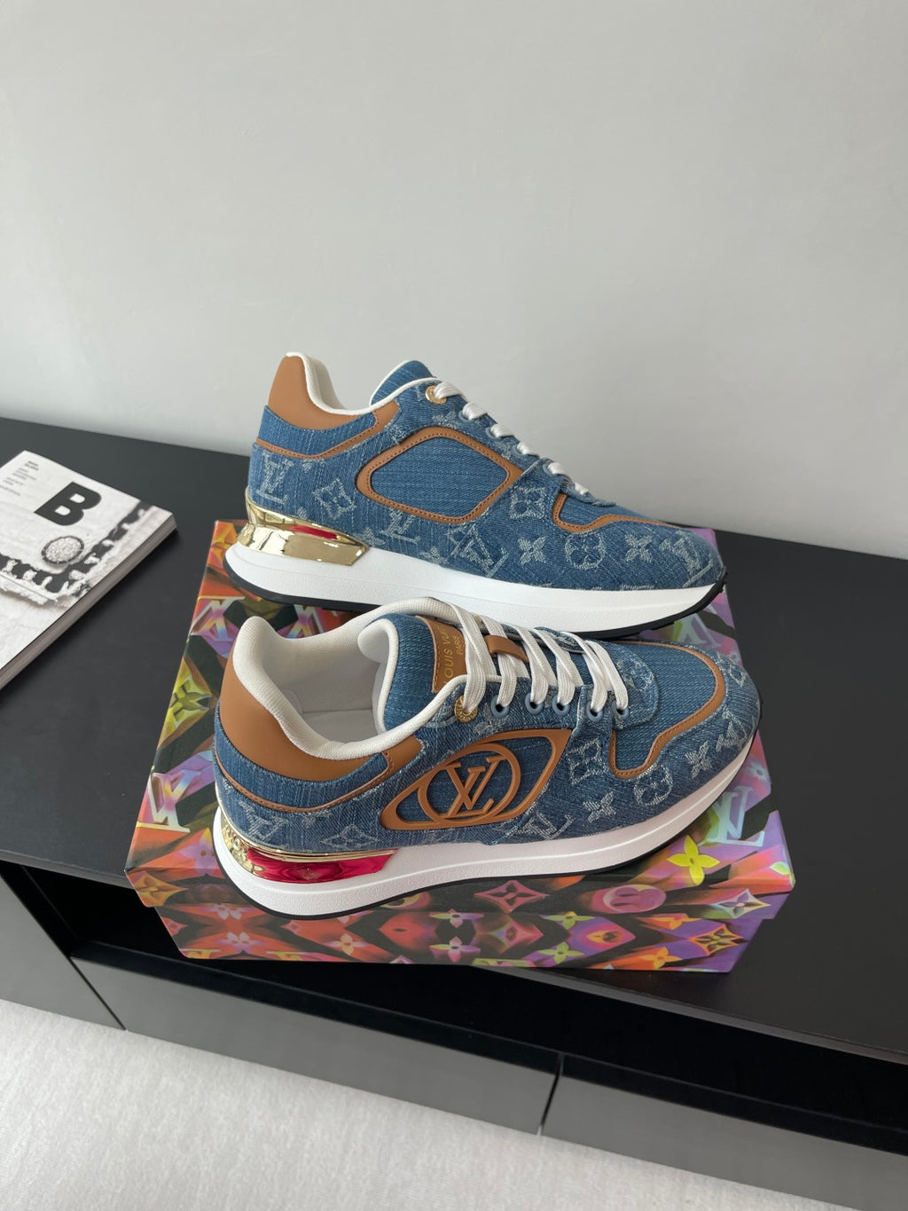 Louis Vuitton ladies sneakers angled view, blue canvas with white laces and red sole accents.