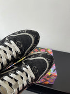 Sneakers toe and side close-up, black textured monogram, white laces, white edge trim