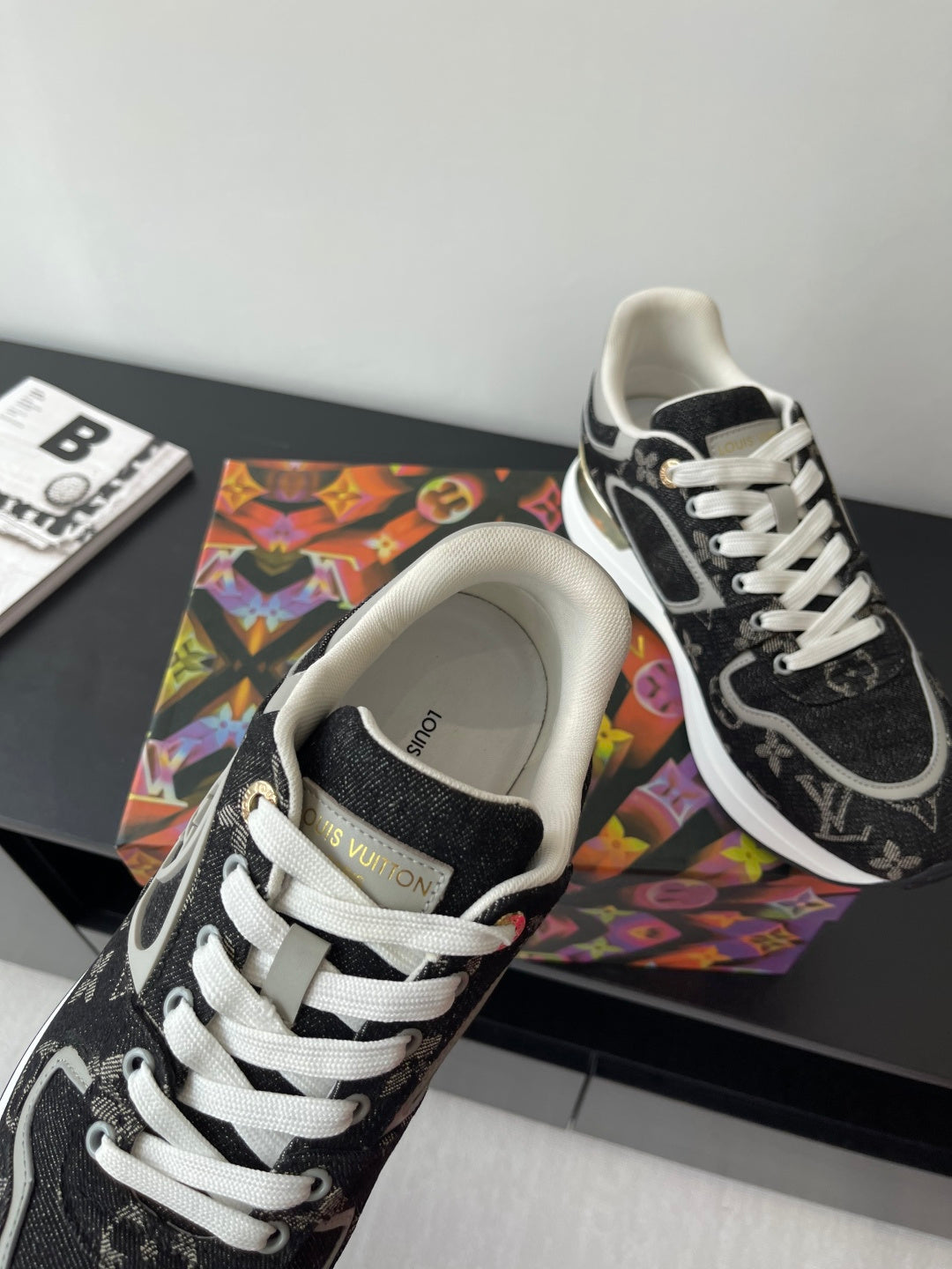 Women’s low-top sneakers close-up, cream lining, black monogram panels, white laces