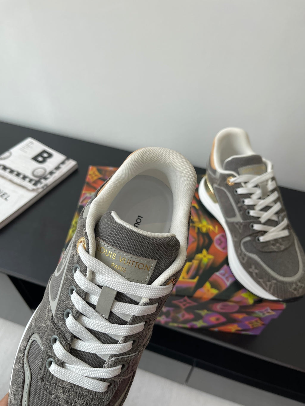 Gray sneaker with white laces and textured fabric lining; close-up on front