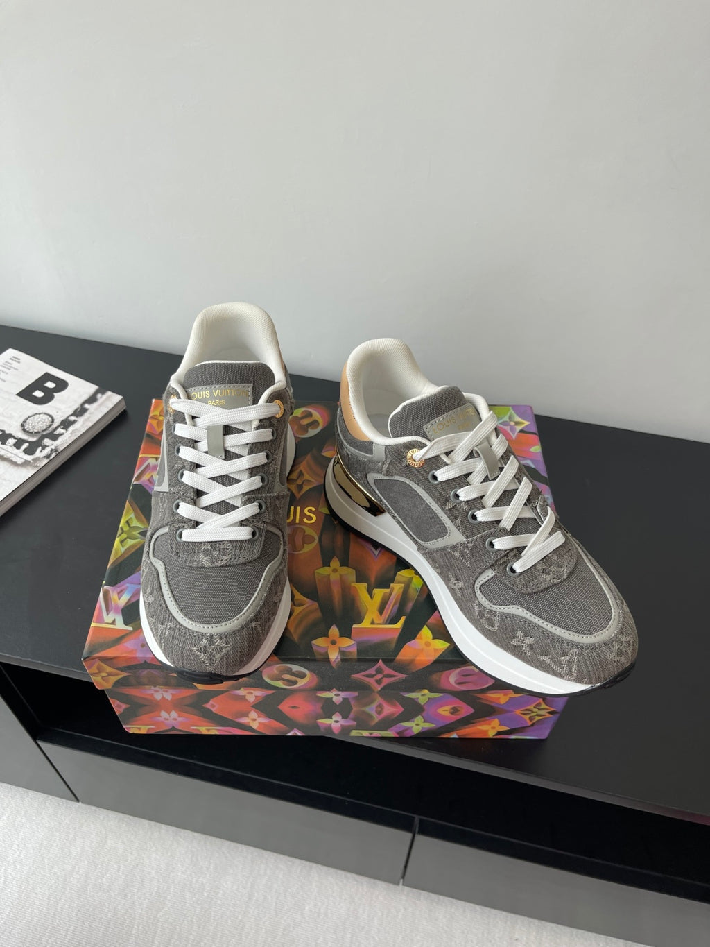 Gray lace-up sneakers with patterned upper and white laces on patterned box