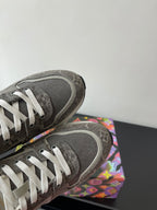 Gray sneakers with white laces; close-up of toe and textured heel panel
