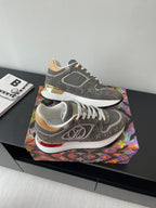 Gray and white lace-up sneakers with patterned upper, stacked midsole details