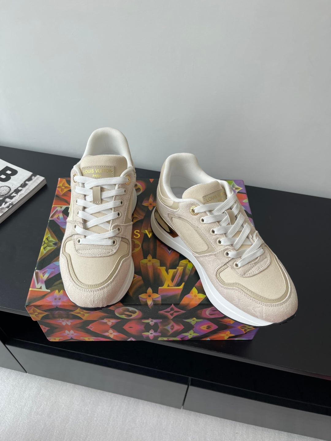 Women's cream lace-up sneakers pair with LV logo on side and gold heel detail