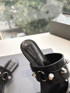 Black slide sandal with silver buckle detail and Balenciaga logo on footbed