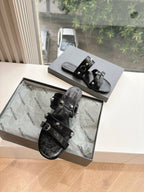 Black slide sandals with two ankle straps and silver buckles, open toe