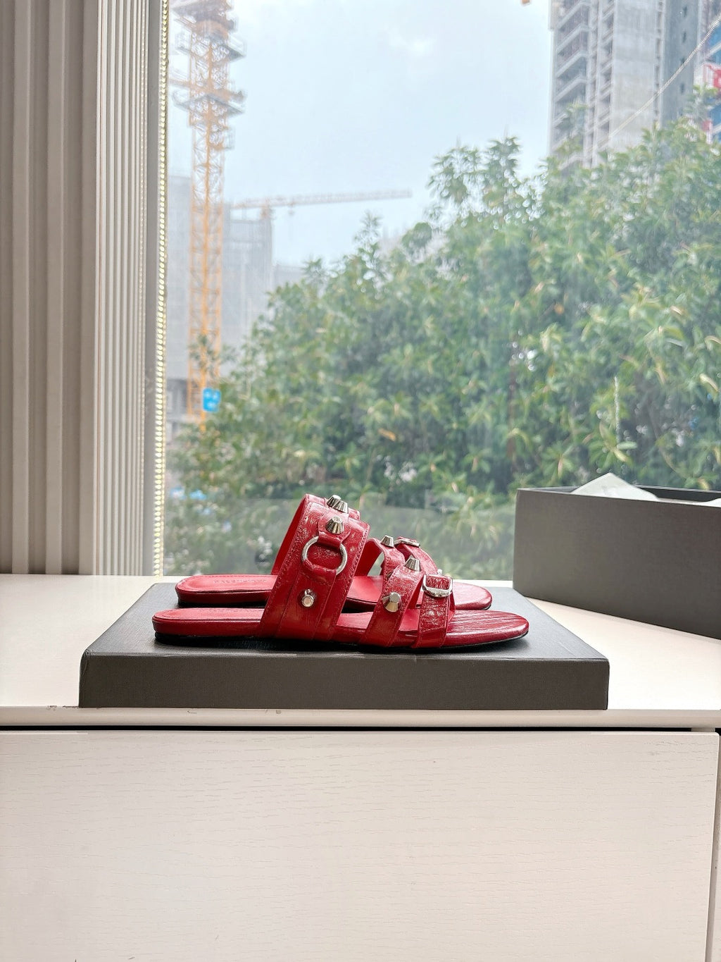 Red slide sandals with metal-studded straps and open toe