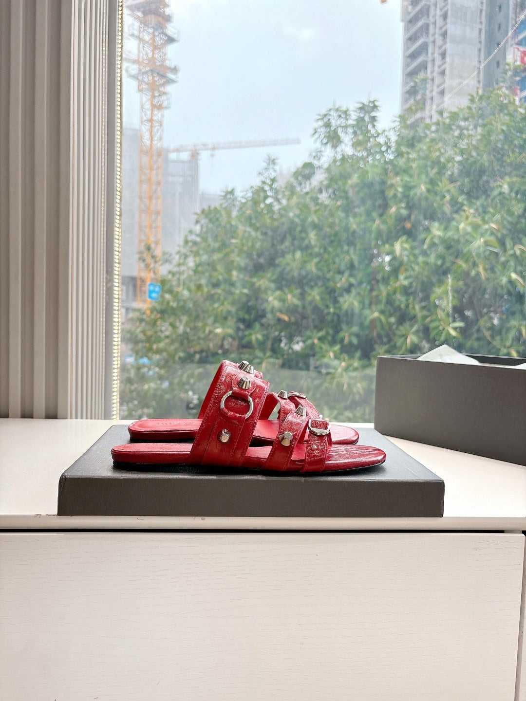 Red slide sandals with metal-studded straps and open toe