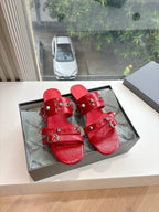 Red slide sandals with multiple buckles and metal studs