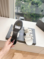 White Balenciaga slide sandals with one visible buckle strap and dark outsole underside