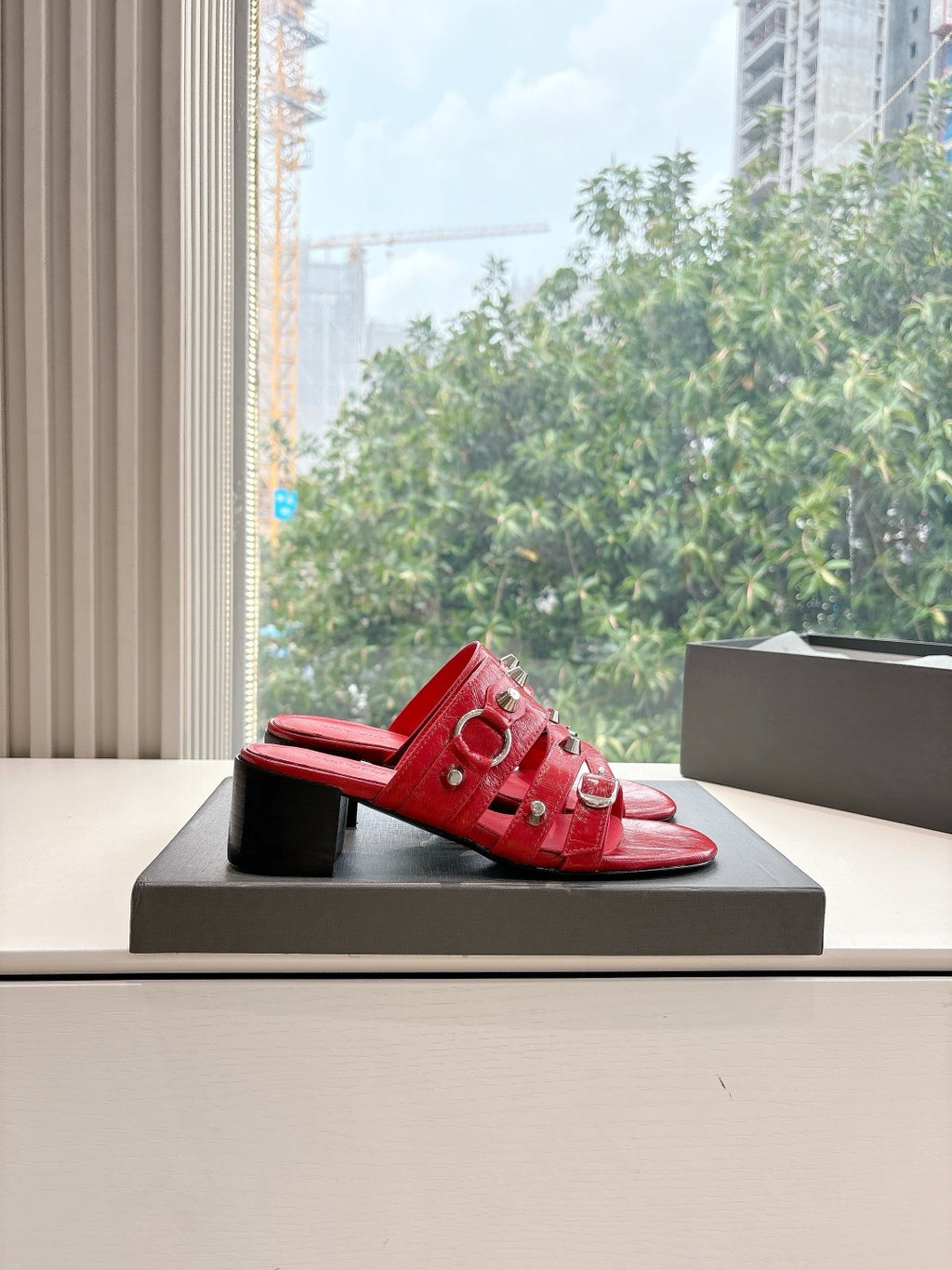 Red mule heeled sandals with strappy top and metal eyelet hardware