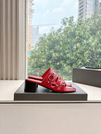 Red mule heeled sandals with strappy top and metal eyelet hardware