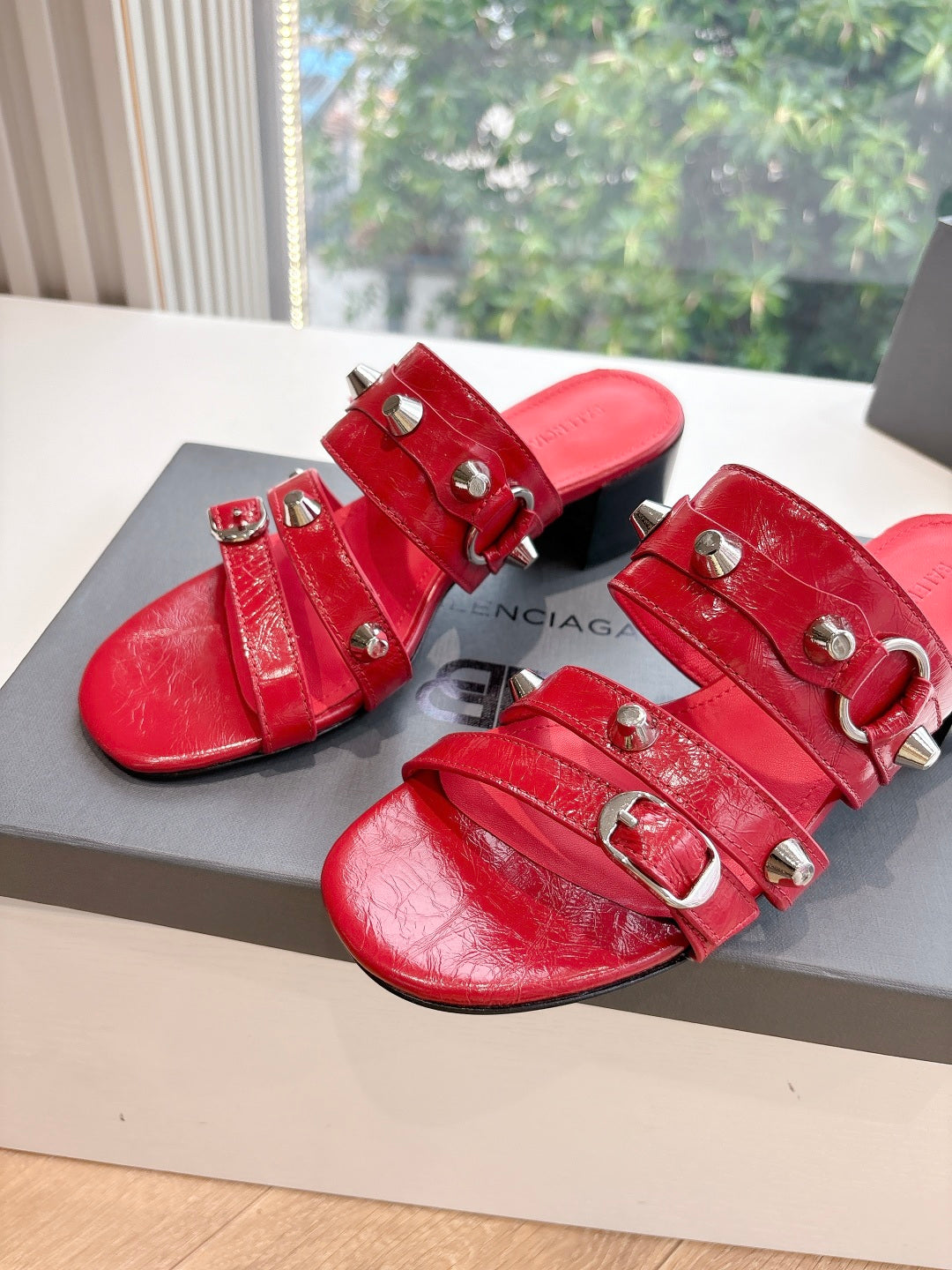 Red strappy heeled sandals with multiple buckles and silver-tone details