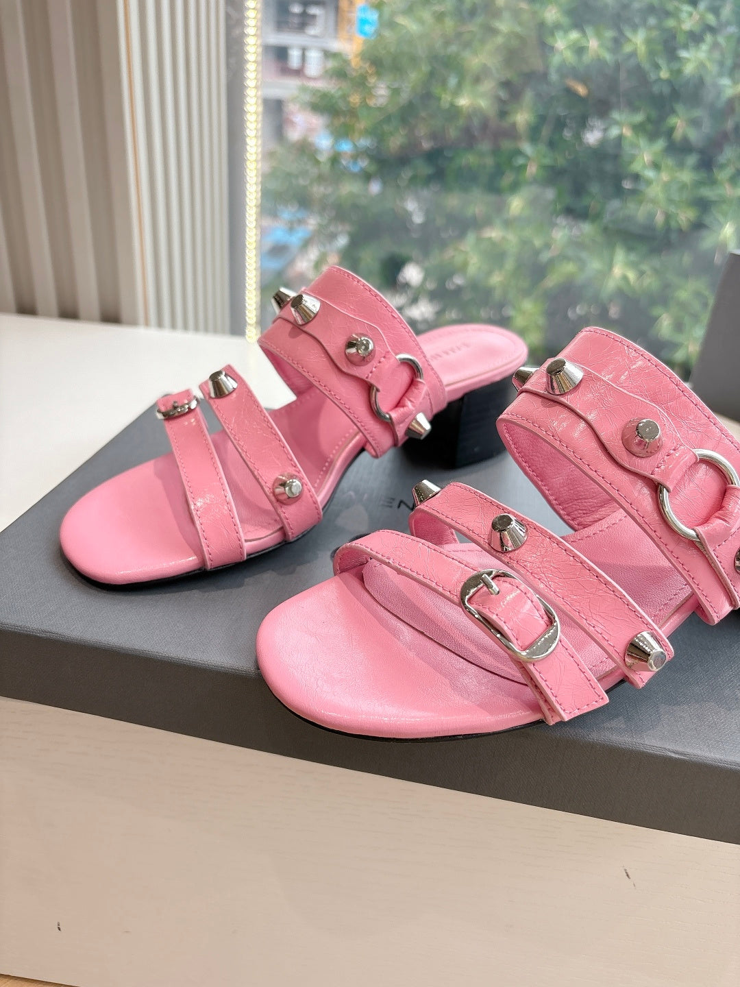 Pink slide sandals with large buckle straps and squared-toe profile