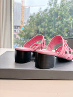 Pink slide sandals showing block heel and open toe with buckle straps