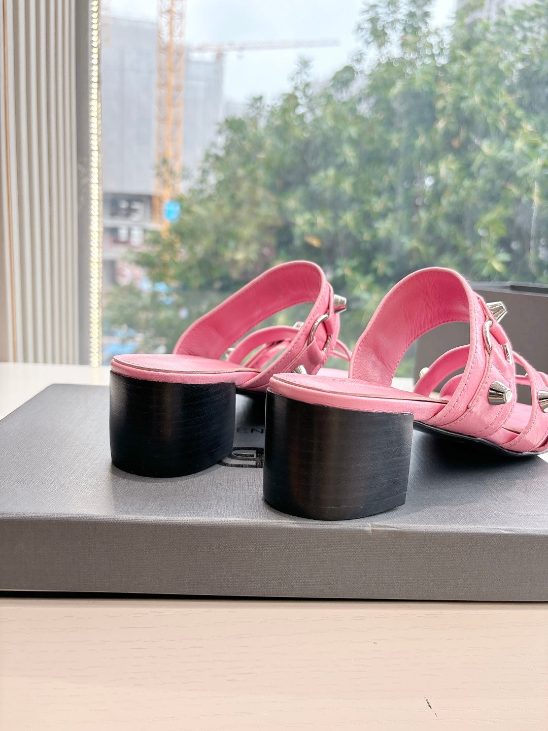 Pink slide sandals showing block heel and open toe with buckle straps