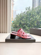 Pink slide sandal on a dark box, low block heel and cuff straps