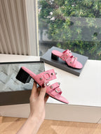 Pink slide sandals with stacked straps and silver-tone buckle details