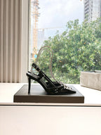 Women's black patent slingback heels with silver jeweled square buckle on box
