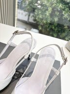 Close-up of women's white slingback heels, showing straps and silver toe buckle