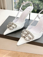 Pair of women's white slingback heels with silver jeweled buckle detail on toe