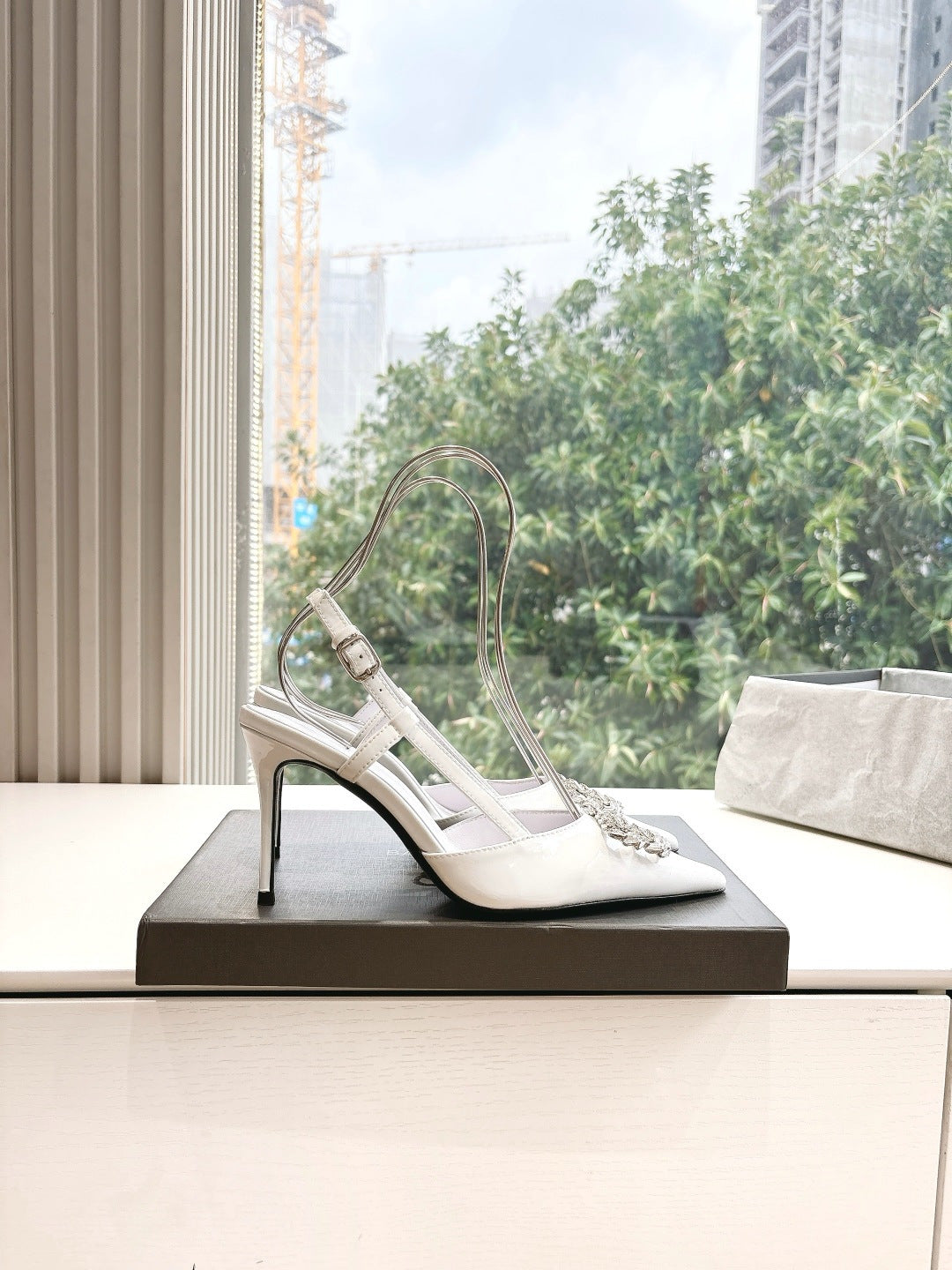 Women's white slingback heels, angled view with silver jeweled toe buckle