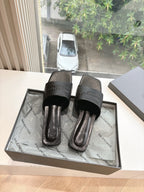 Balenciaga women's black slide sandals, side view, with embossed logo on strap