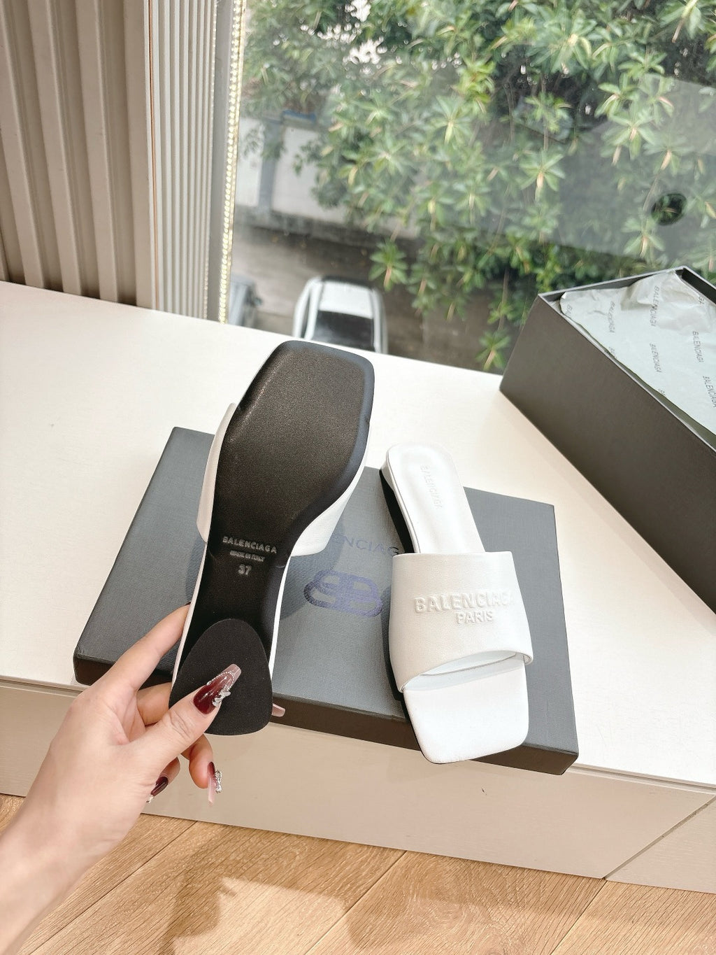 Balenciaga women's slide sandals showing black outsole and white strap, in box