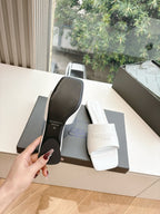 Balenciaga women's slide sandals showing black outsole and white strap, in box