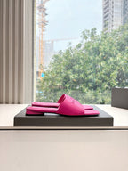Pink Balenciaga slide sandals on a gray display box, open-toe slides.