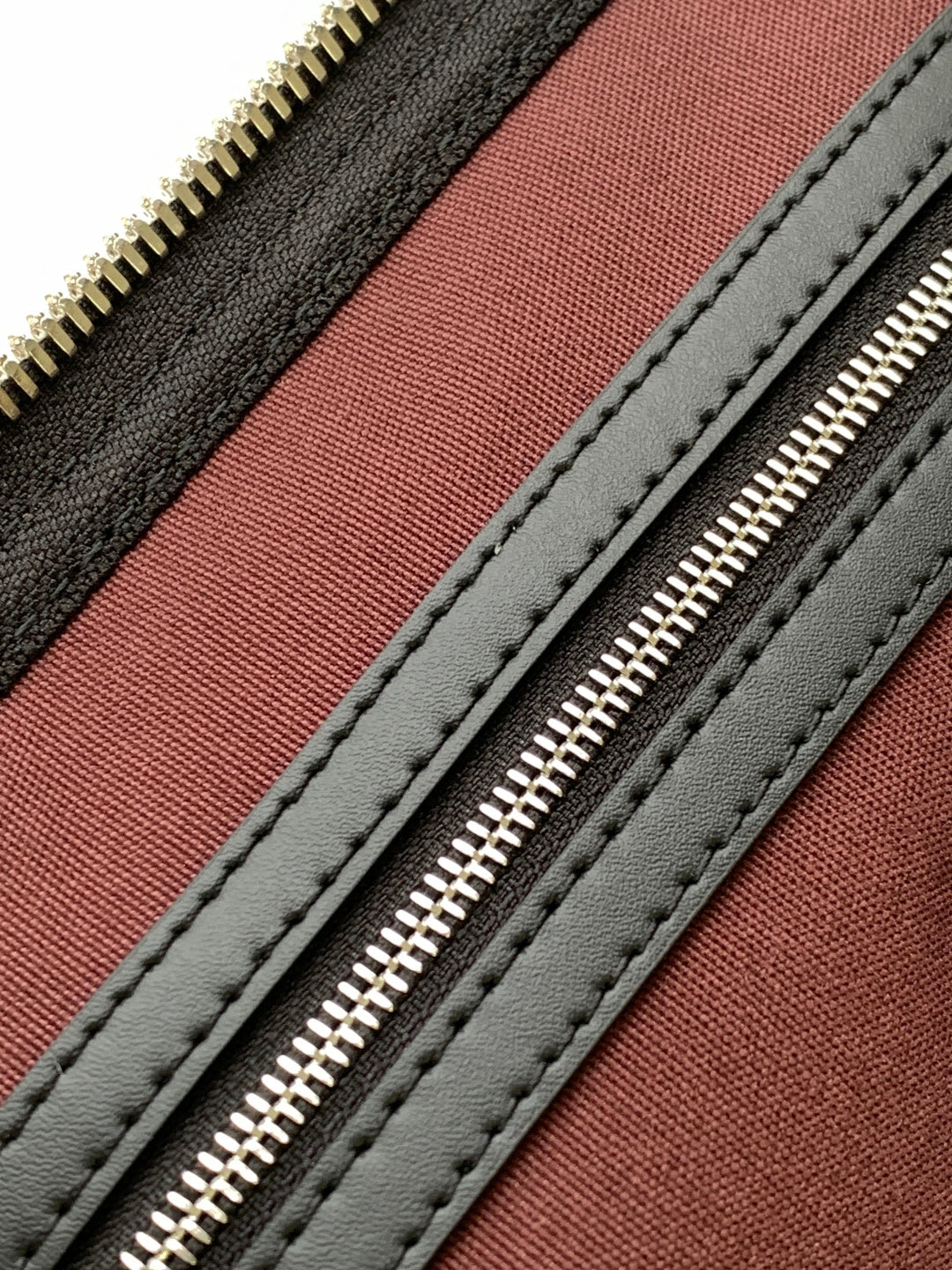 Monogram duffel bag interior lining with red panel and black stitched edges