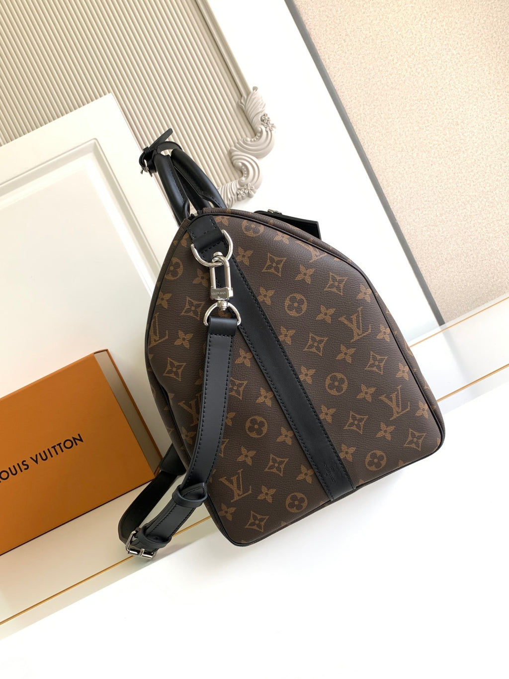 Monogram duffel bag with black leather strap and top zipper