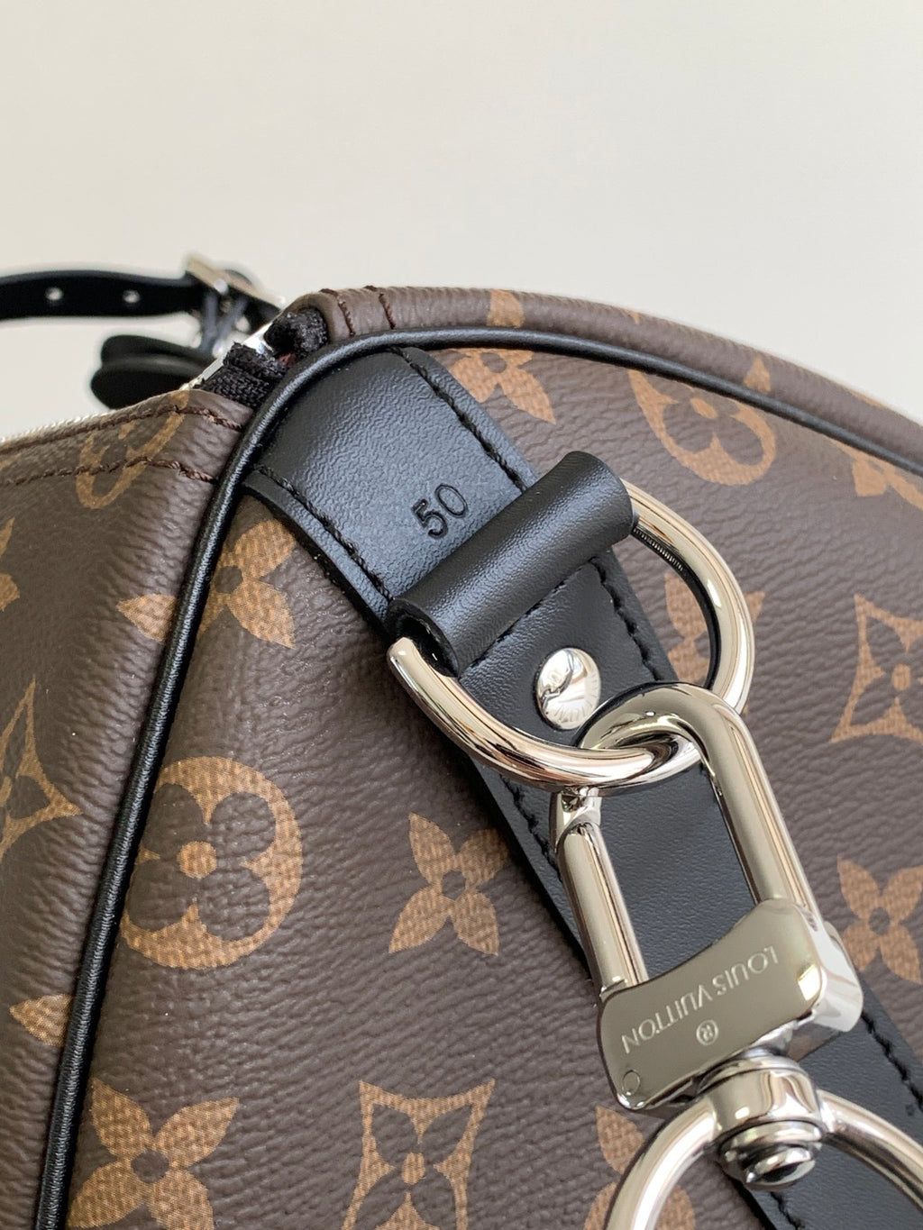 Monogram duffel bag close-up of black leather strap with metal clasp